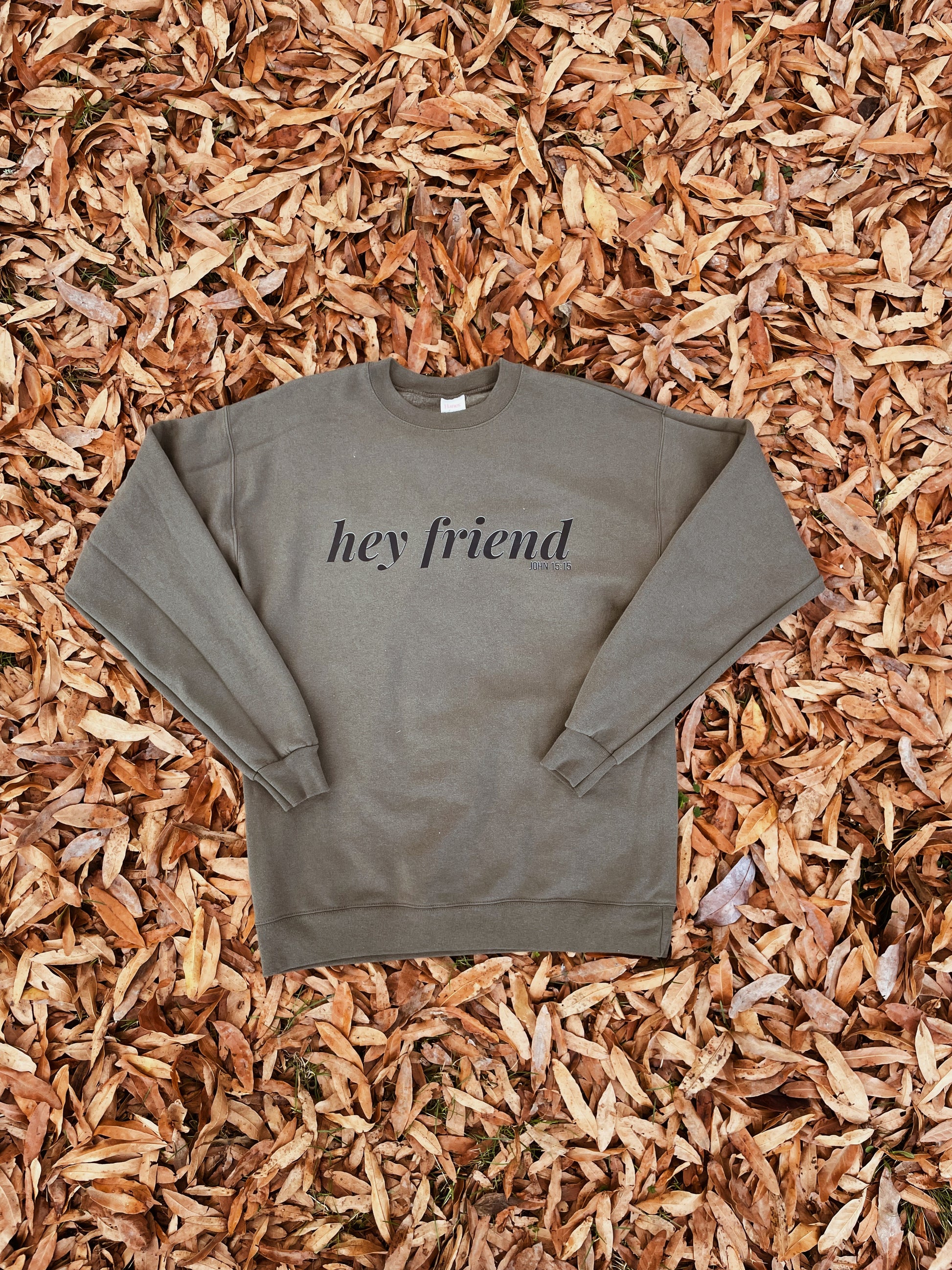 Sweatshirt with 'hey friend' text on a mulch background